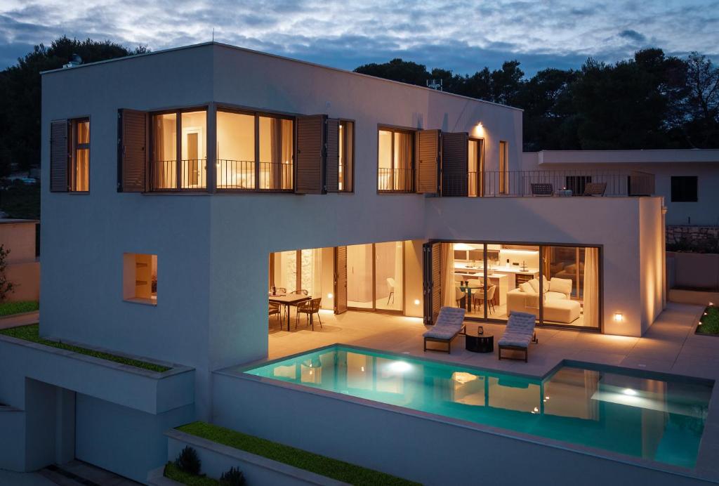 a house with a swimming pool in front of it at Lemon Tree Villa in Splitska