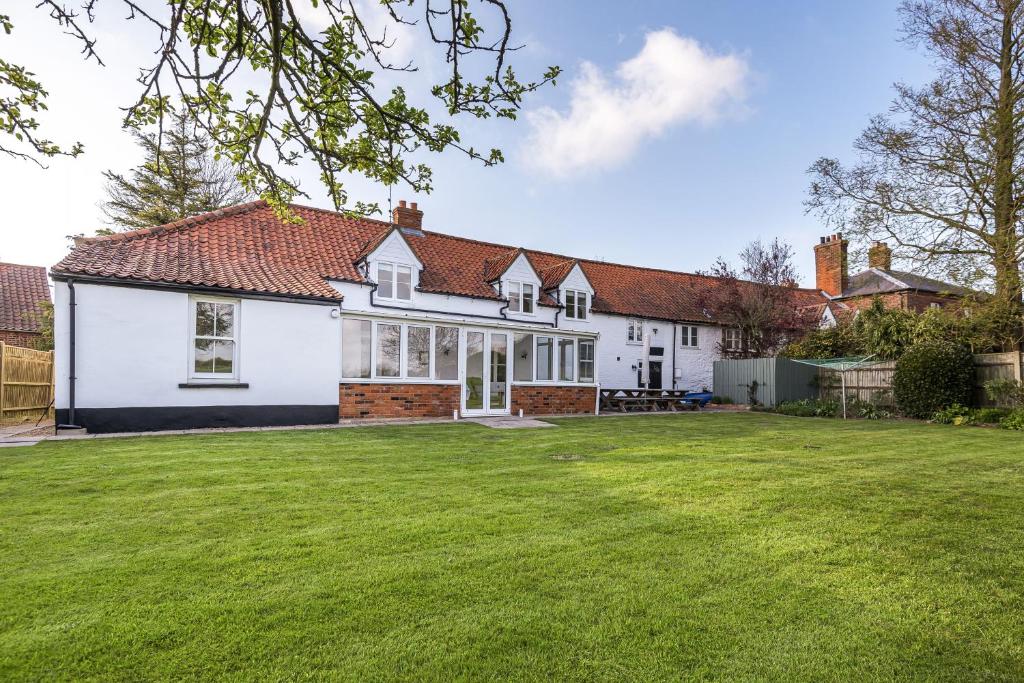 a large white house with a large yard at Nelson Lodge in Burnham Market