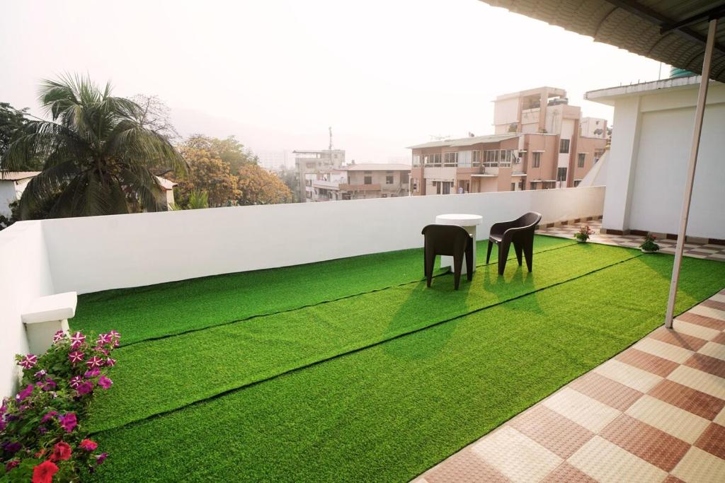a balcony with a table and chairs on the grass at The Guwahati Penthouse in Guwahati