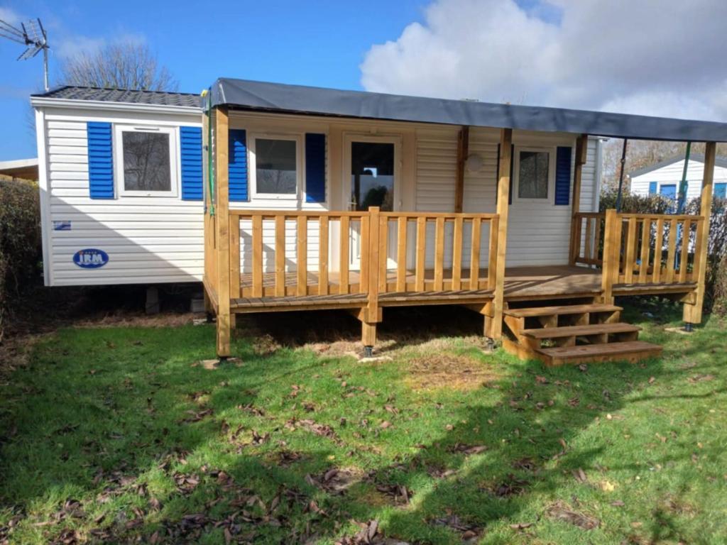 a tiny house with a porch and a deck at Escapade aux Peupliers in Vironchaux