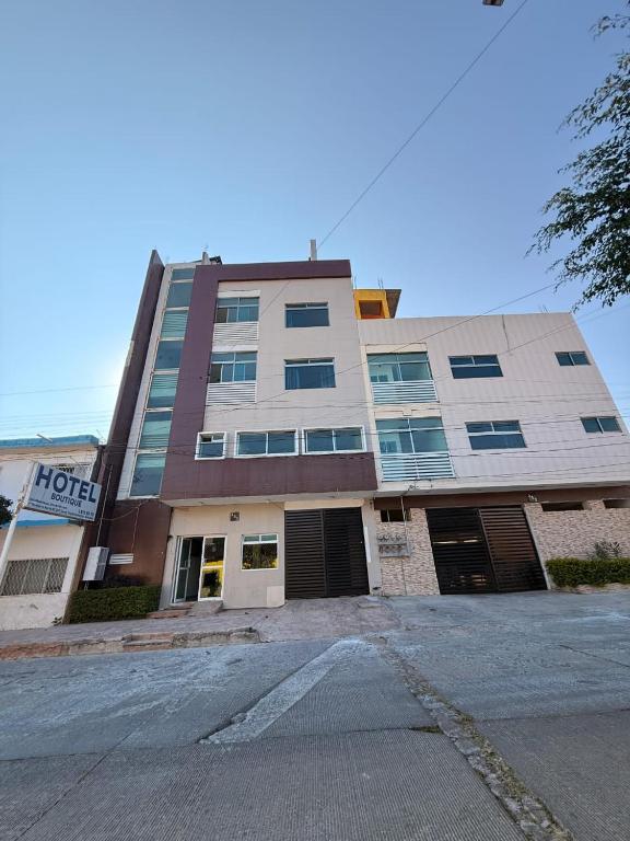 a building with a parking lot in front of it at Hotel Boutique Los Laureles in Tuxtla Gutiérrez