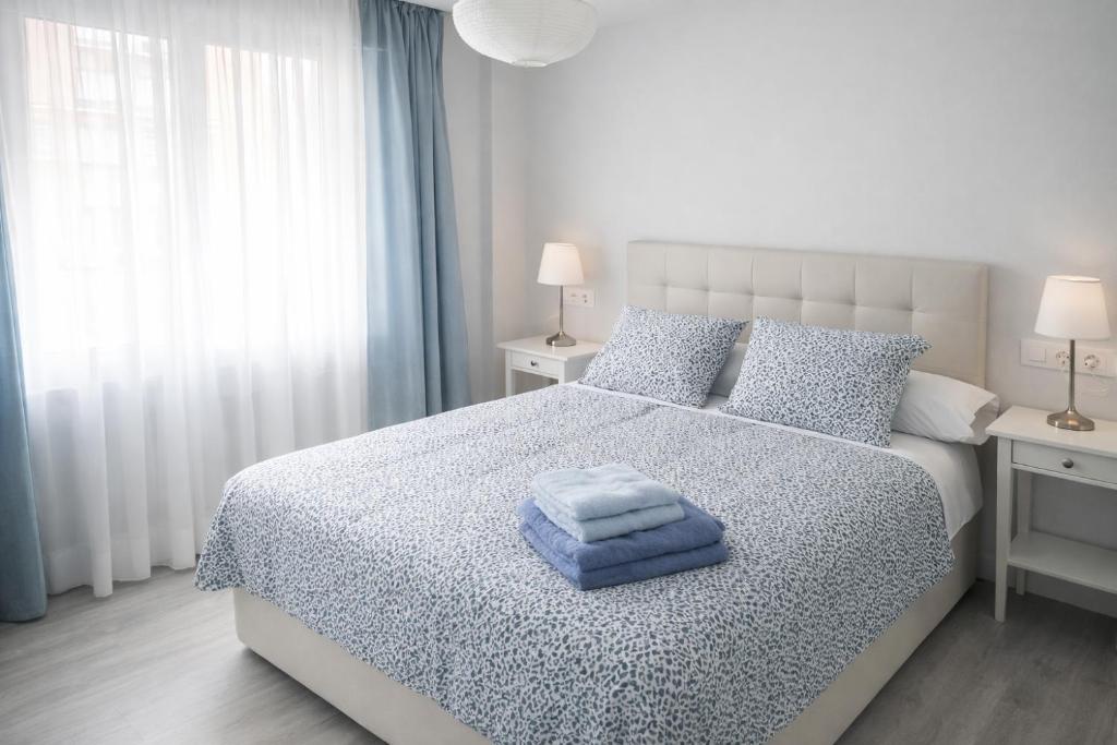 a bedroom with a bed with a blue towel on it at San Lorenzo House in Gijón