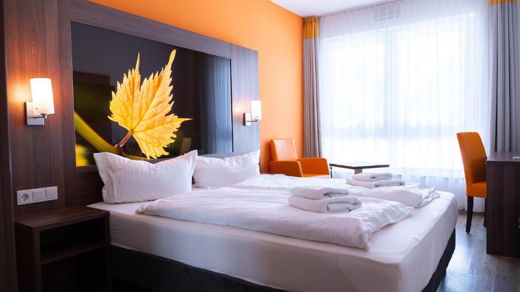 a hotel room with a large bed with towels on it at Alembra - Wein Style Hotel in Trier
