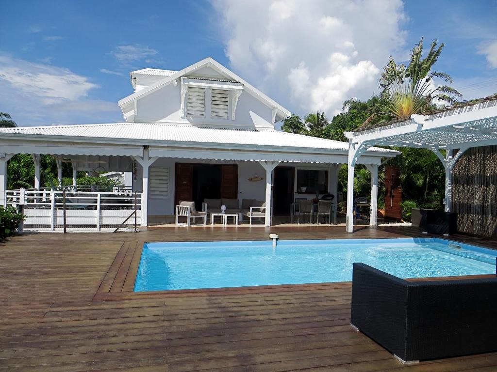 a villa with a swimming pool and a house at Villa Paradis - vue mer, piscine et jacuzzi in Sainte-Anne