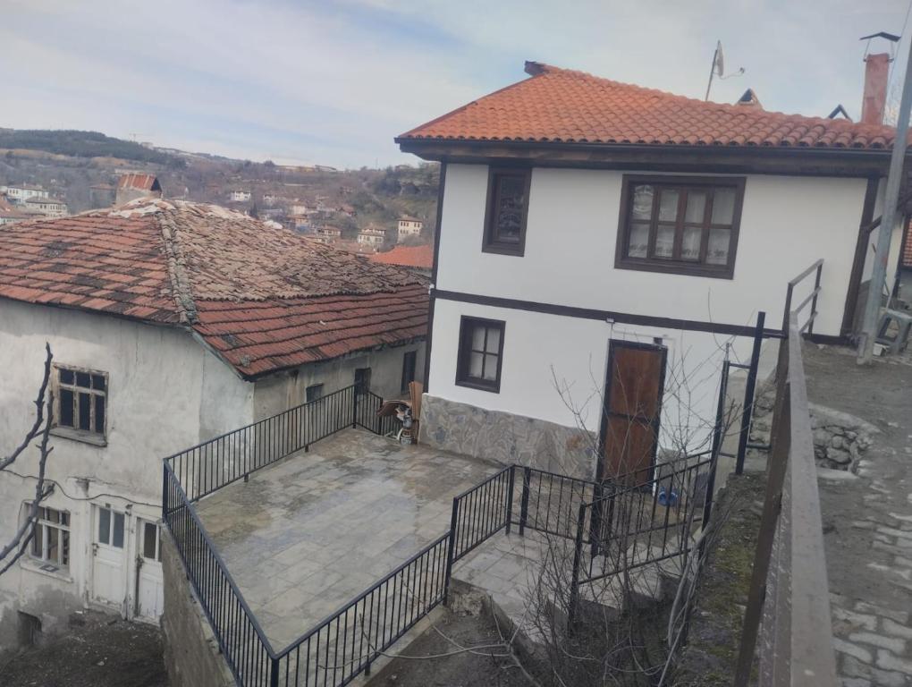 a dog sitting on a balcony of a white house at Minihome Konak in Safranbolu