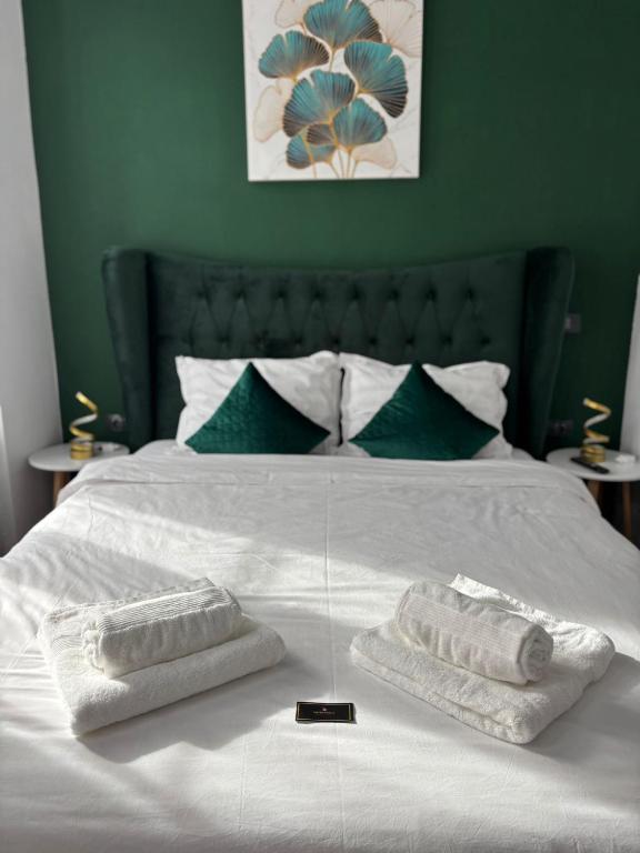a white bed with two towels on top of it at Kromatic 5 Boutique Studios - Old town Center in Braşov