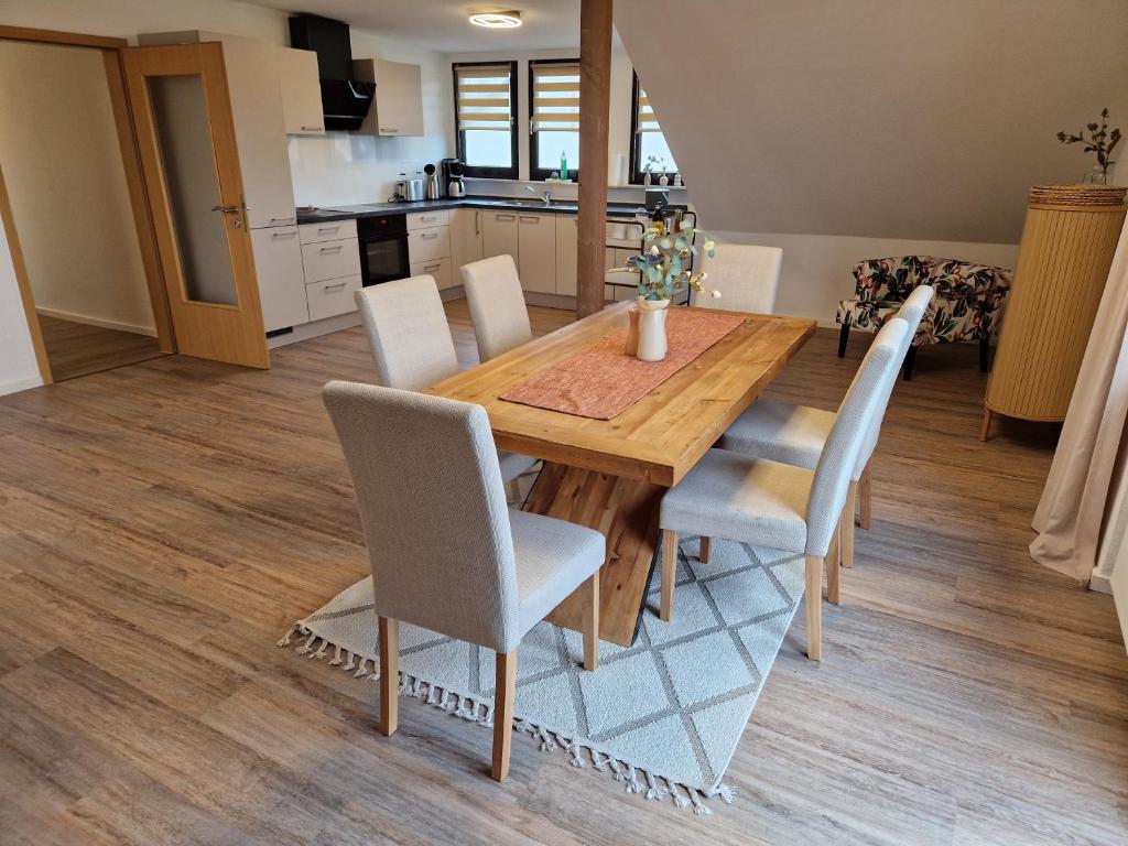 eine Küche und ein Esszimmer mit einem Holztisch und Stühlen in der Unterkunft Panoramablick Eitelborn in Eitelborn