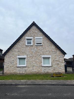 a brick house with three windows on a street at CasaCremer 3 in Übach-Palenberg