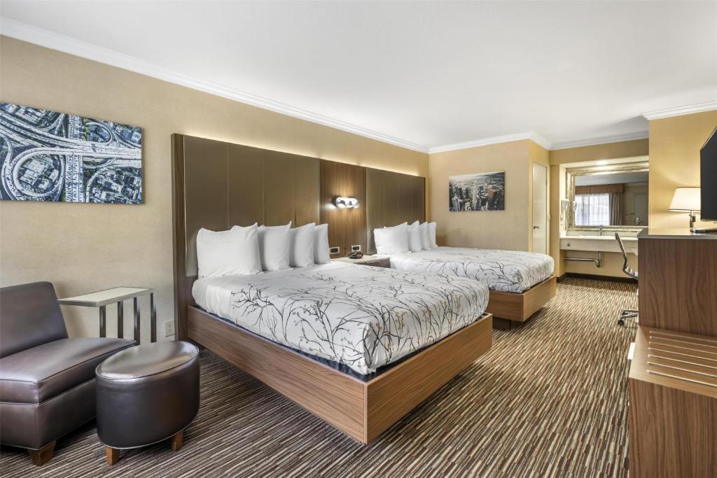 a hotel room with two beds and a chair at Best Western Airpark Hotel - LAX Airport LA Stadium in Inglewood