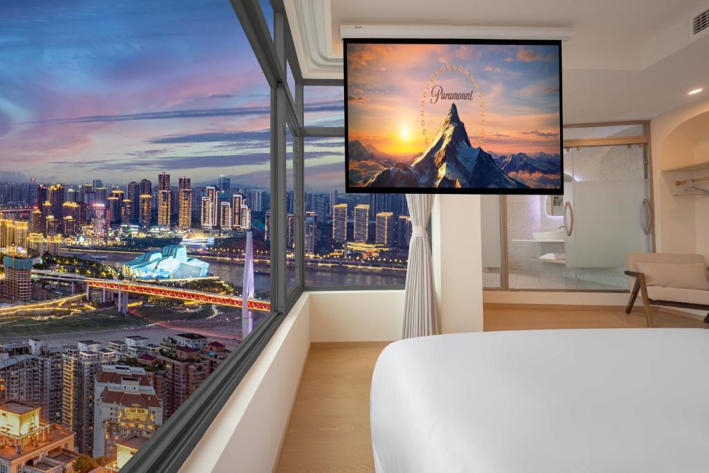 a bedroom with a large window with a view of a city at 妮可酒店解放碑店 in Chongqing