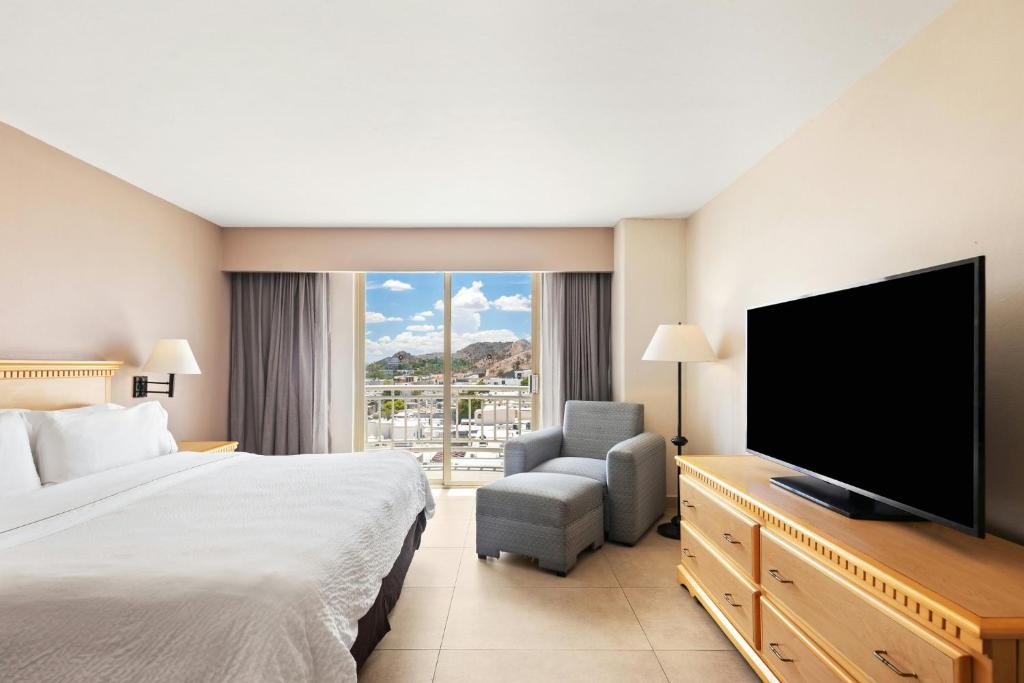 a hotel room with a bed and a flat screen tv at Fiesta Inn Express Hermosillo in Hermosillo
