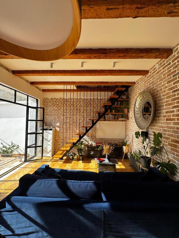a living room with a couch and a brick wall at Exceptional Home-5 min from Porto Montenegro Tivat in Tivat