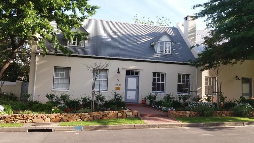 a white house with a blue door at 3 on Roux in Franschhoek