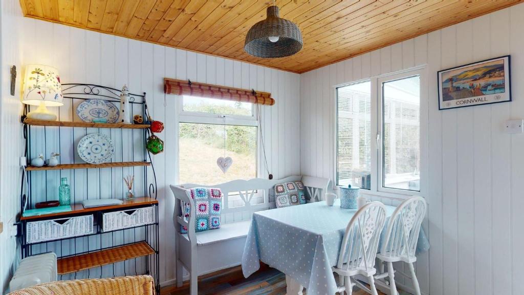 a dining room with a table and chairs at F67 Ischia, Riviere Towans in Hayle