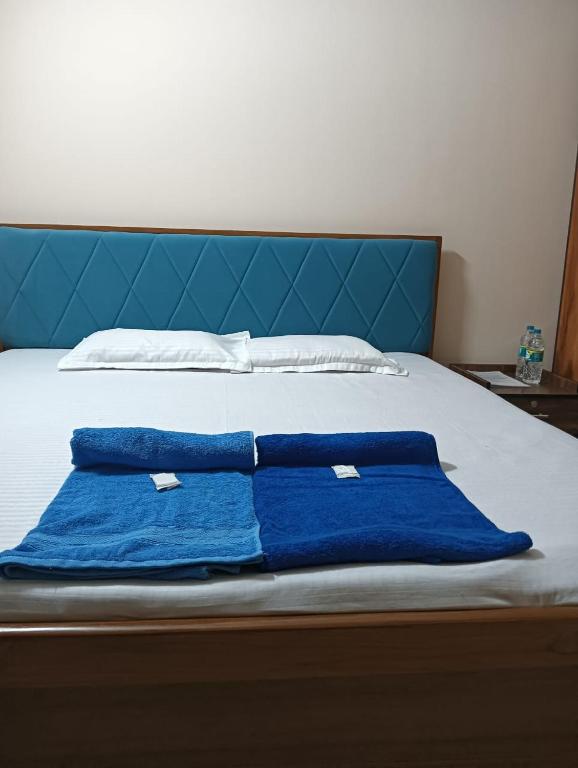 two blue towels are laying on a bed at Swagat Lodge in Chāngsāri