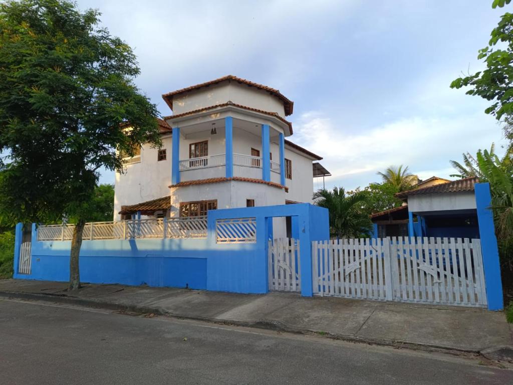 a blue fence in front of a house with a blue gate at Suíte Externa Casal in Rio das Ostras