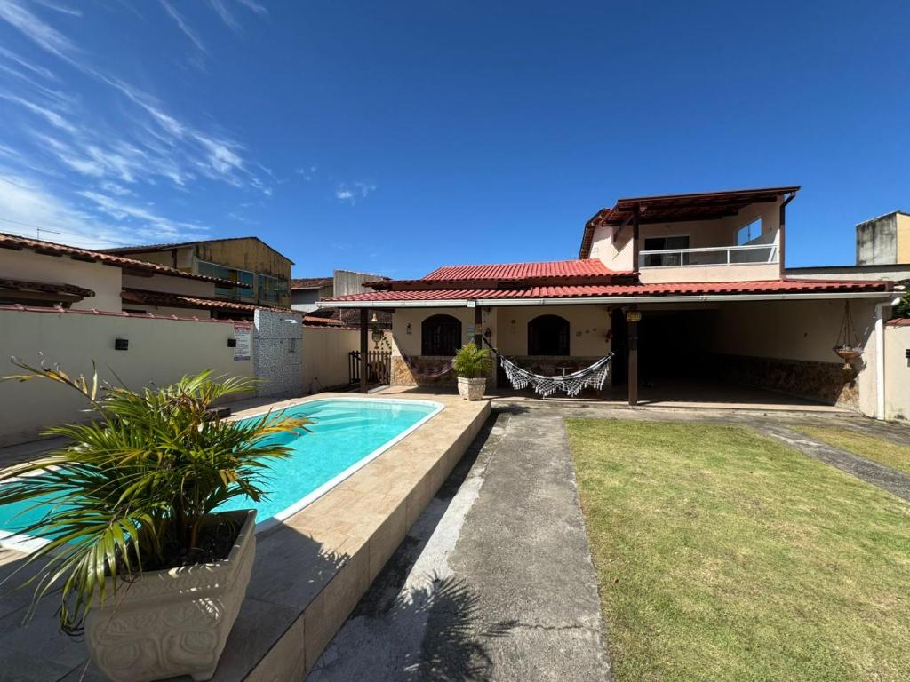 a house with a swimming pool in the yard at CasaPraiaSol1 in Rio das Ostras