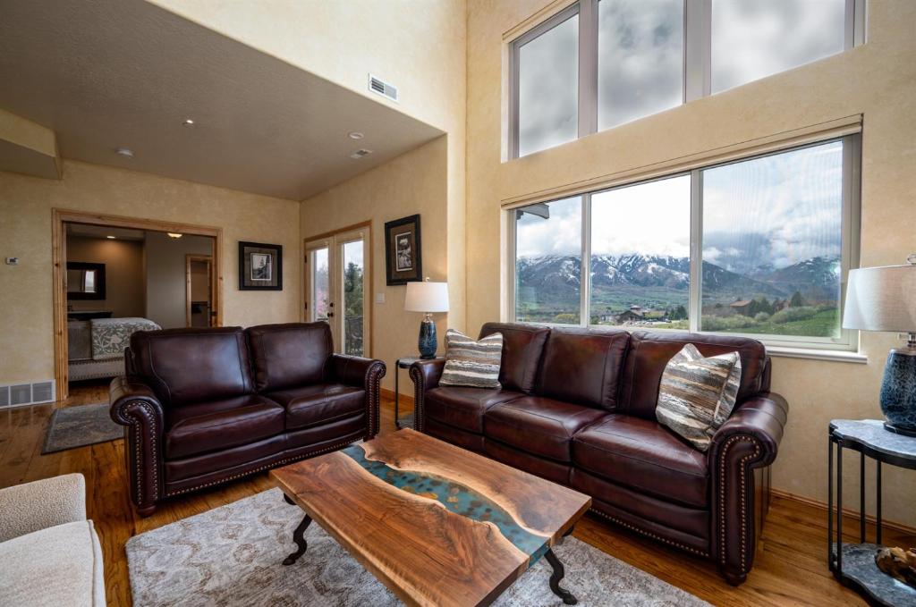 a living room with leather furniture and a large window at Snowcrest C304Ski Getaway Hot Tub & Theater Room in Eden