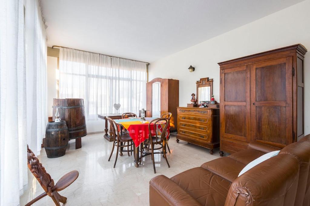 a living room with a couch and a table and chairs at Il Melograno, appartamento privato in Cavriago
