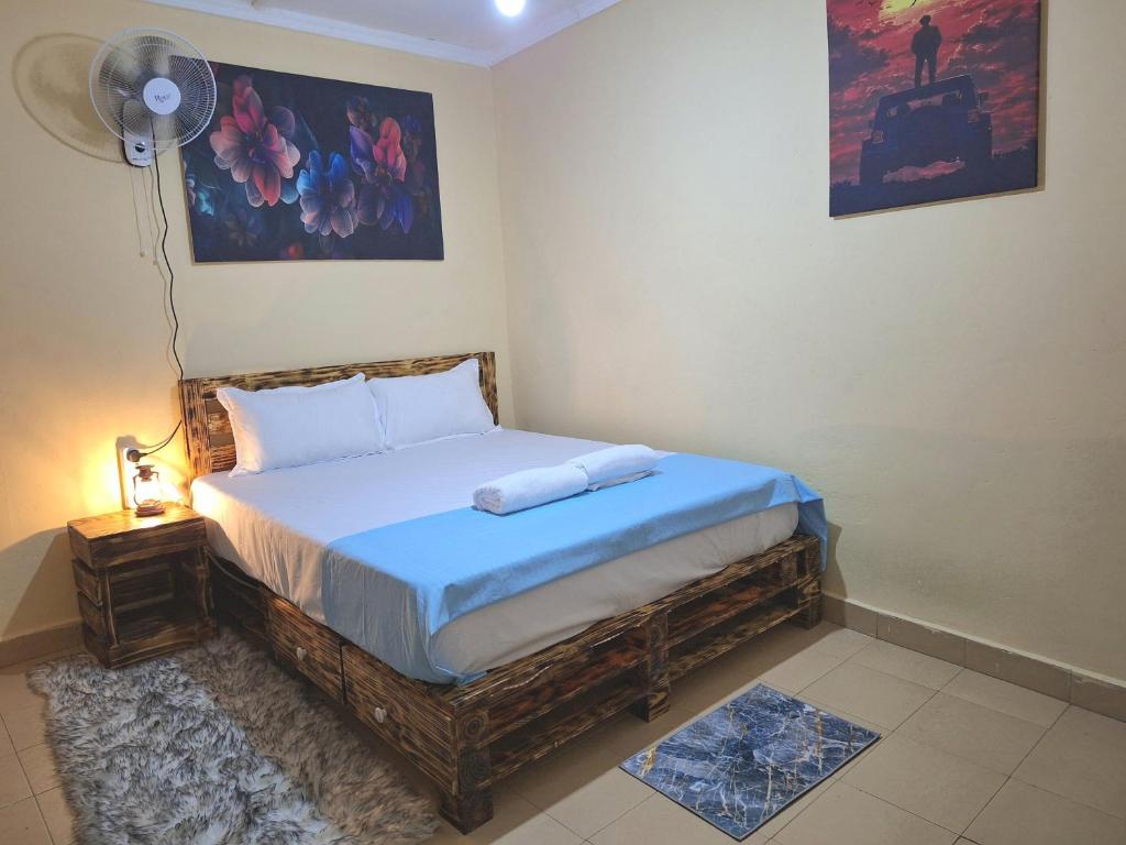 a bedroom with a bed with a fan on the wall at Janari Homes in Diani Beach
