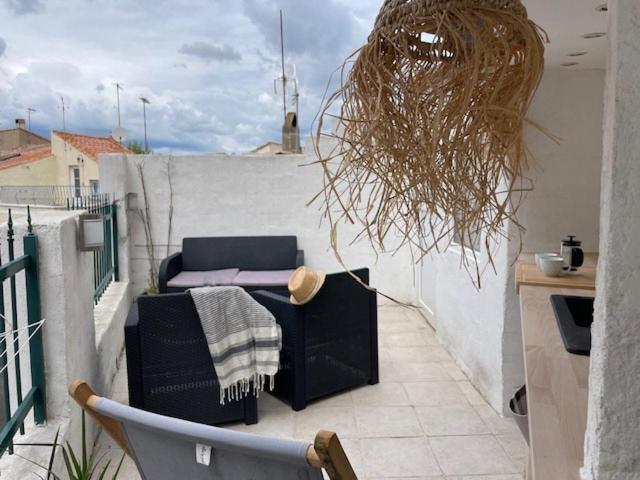 a balcony with a chair and a table on a roof at la terrasse in Marseillan
