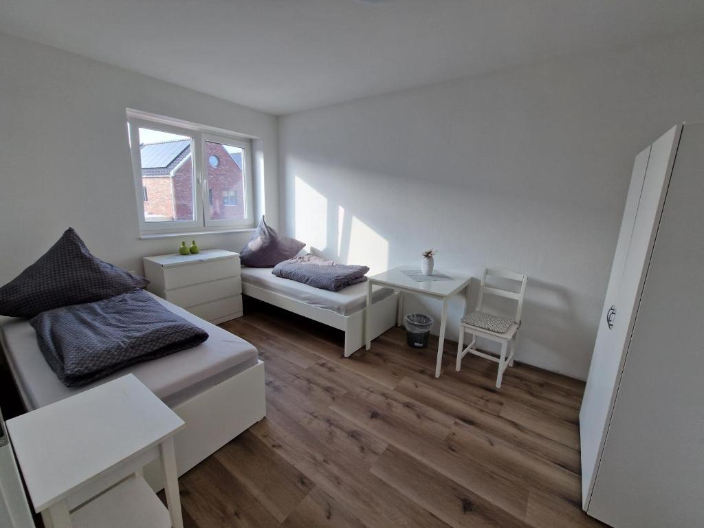 a small room with a bed and a table at Monteurwohnung RoomWork24 - 10 Betten - Twistringen in Twistringen