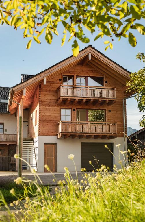 a log house with a balcony and a deck at Bauernhofurlaub Eggcellence in Teisendorf