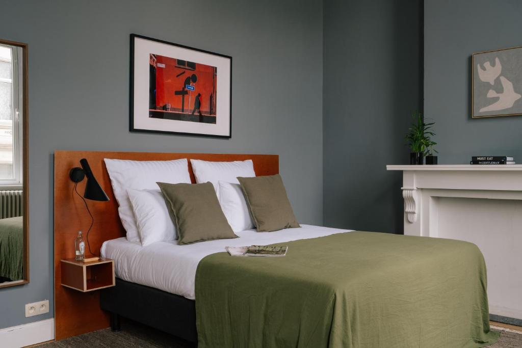 a bedroom with a bed with a green blanket at A Place Antwerp - Boutique Suites & Flats - Schuttershofstraat 1 in Antwerp