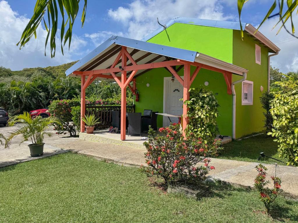 a green house with a blue roof at Bungalows Arc en Ciel in Sainte-Anne