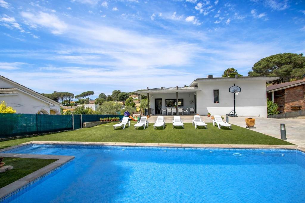 a swimming pool with chairs and a house at Catalunya Casas Modern Marvel,15 min to Costa Brava beaches! in Sils