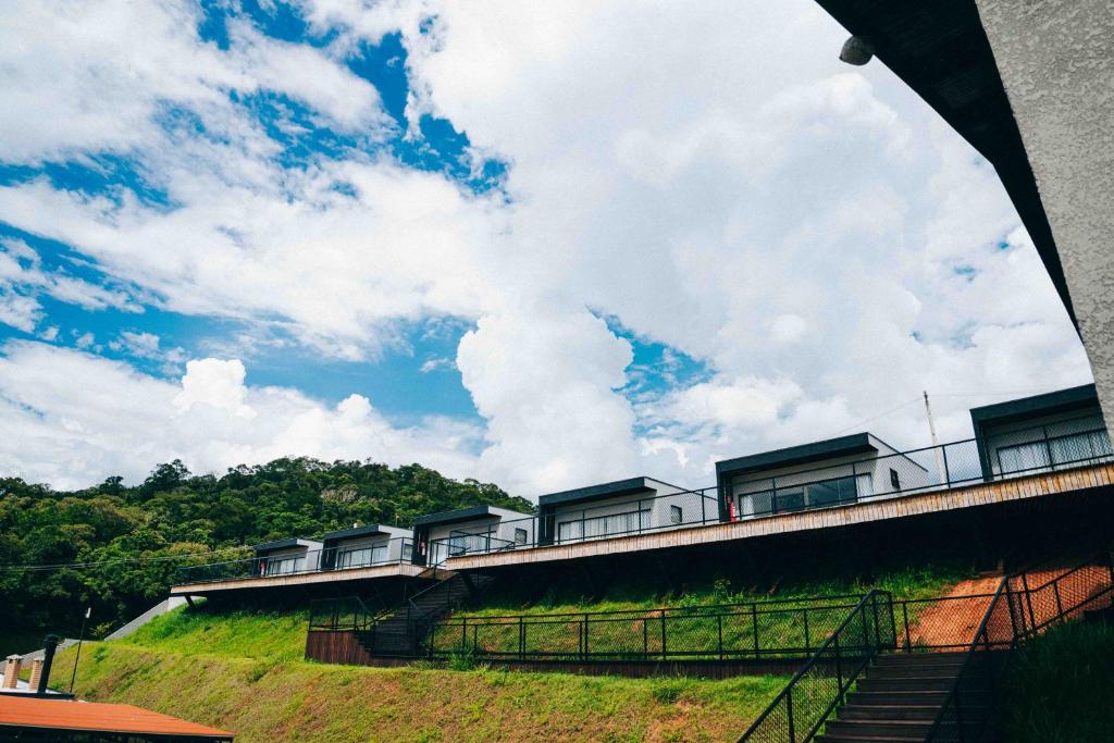 a building on top of a hill with a cloudy sky at Roga Village in Atibaia