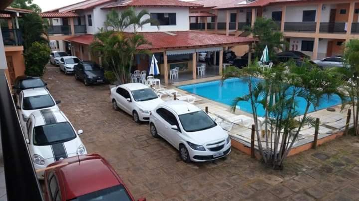 a group of cars parked next to a pool at Pousada Lorenise in Guriri