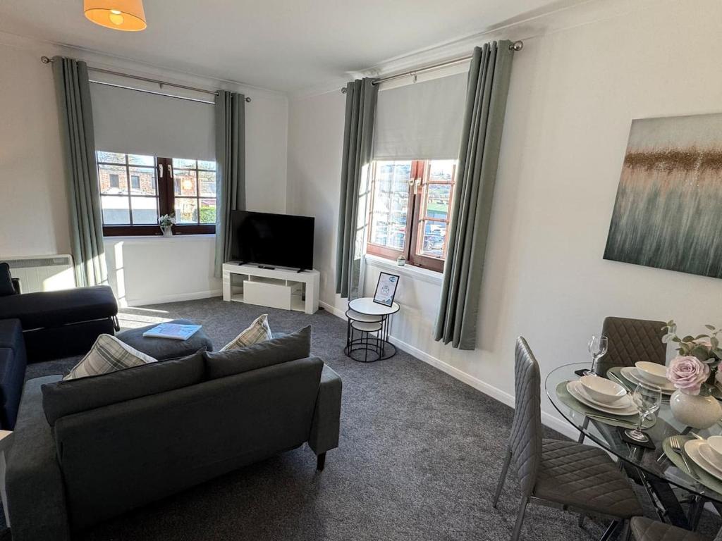 a living room with a couch and a table at Central 1BR Apt with Parking in Auchterarder