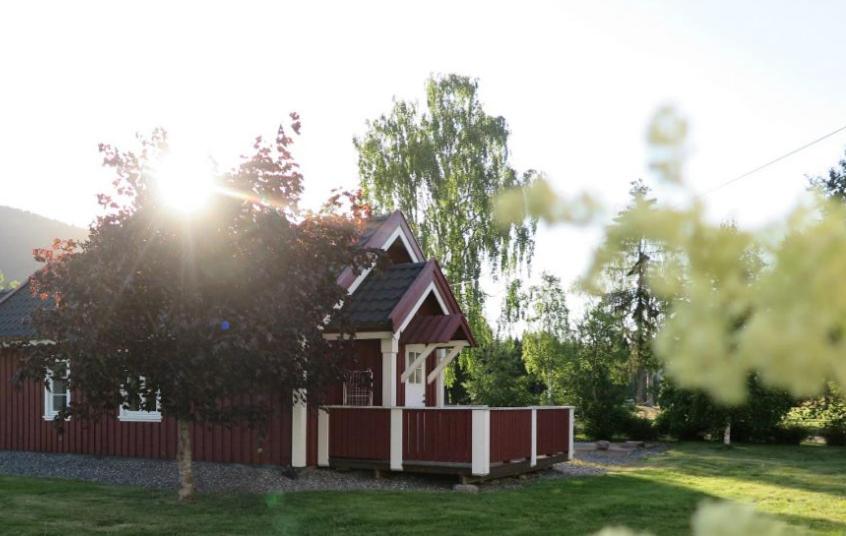 a small red and white house in a yard at Cosy Cottage Vollheim in Lillehammer