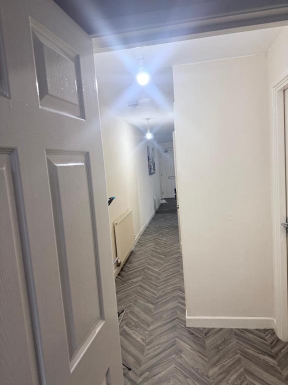 an empty hallway with a white door and a room at Golden Stay in Wyken