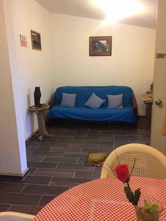 a blue couch in a living room with a table at Casa Sustentable Monarca Angangueo in Mineral de Angangueo