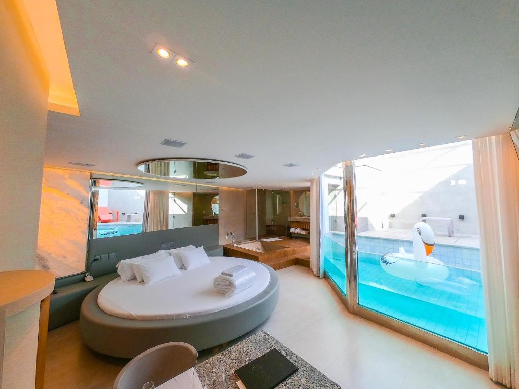 a bedroom with a large bed and a swimming pool at Motel Cavalo Branco in Belo Horizonte