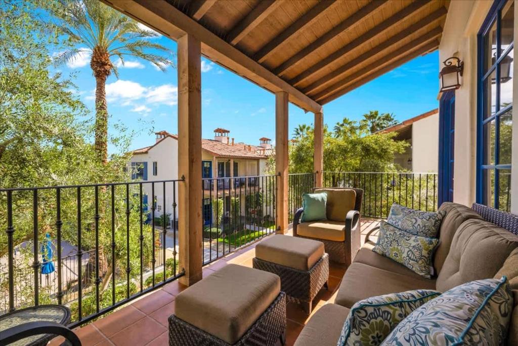 a porch with a couch and chairs and a fence at Poolside Greens 2BR Legacy Villa in La Quinta