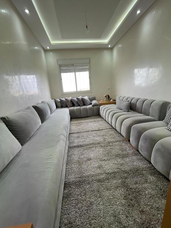 a large living room with long couches in a room at Appartement Moderne à Temara in Temara