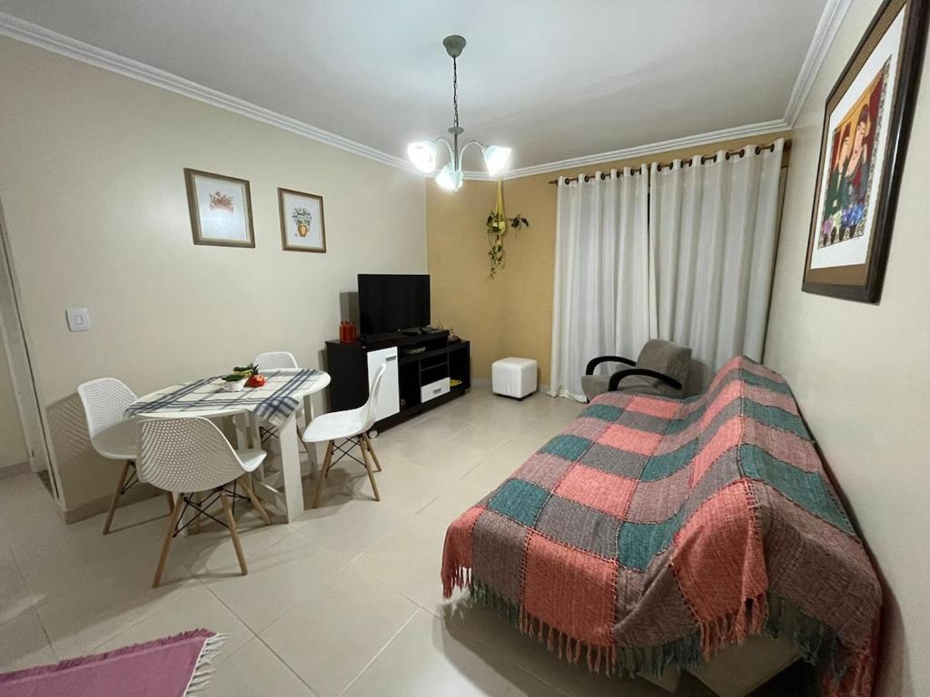 a bedroom with a bed and a table with chairs at AP perto do HSVP com estacionamento in Passo Fundo