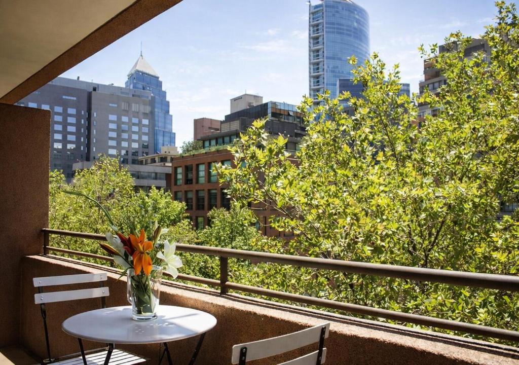 a vase of flowers on a table on a balcony at Apartamentos Costanera Centre in Santiago