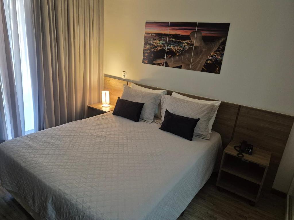 a bedroom with a large bed with two pillows at Suíte Premiere in Rio de Janeiro