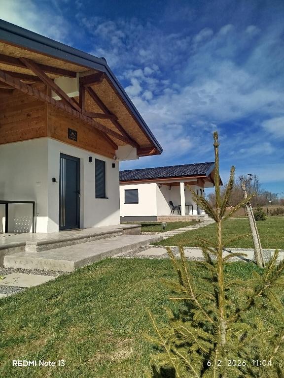 a white house with a wooden roof at Sunny Apartments in Malo Laole