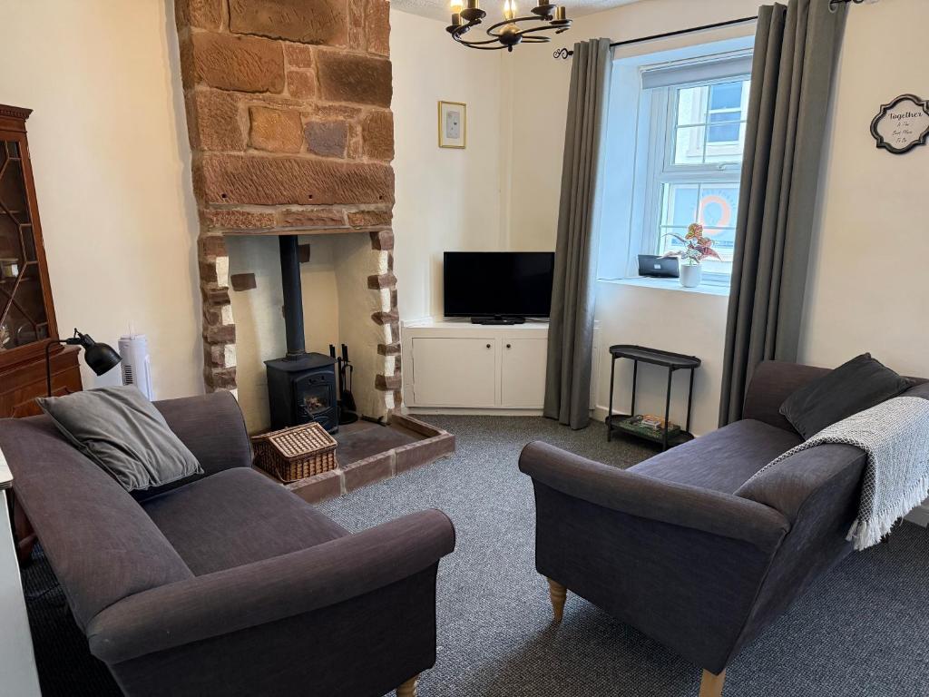 a living room with two couches and a fireplace at 18 Main Street in St Bees