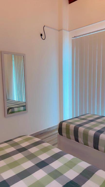 a bedroom with a bed and a mirror in it at Villa Auxesiaa in Wattala