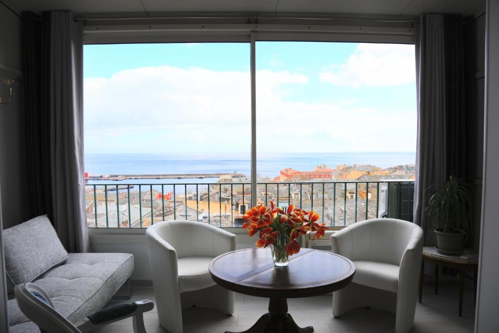 a living room with a table and chairs and a large window at Maison TORTONI in Bastia