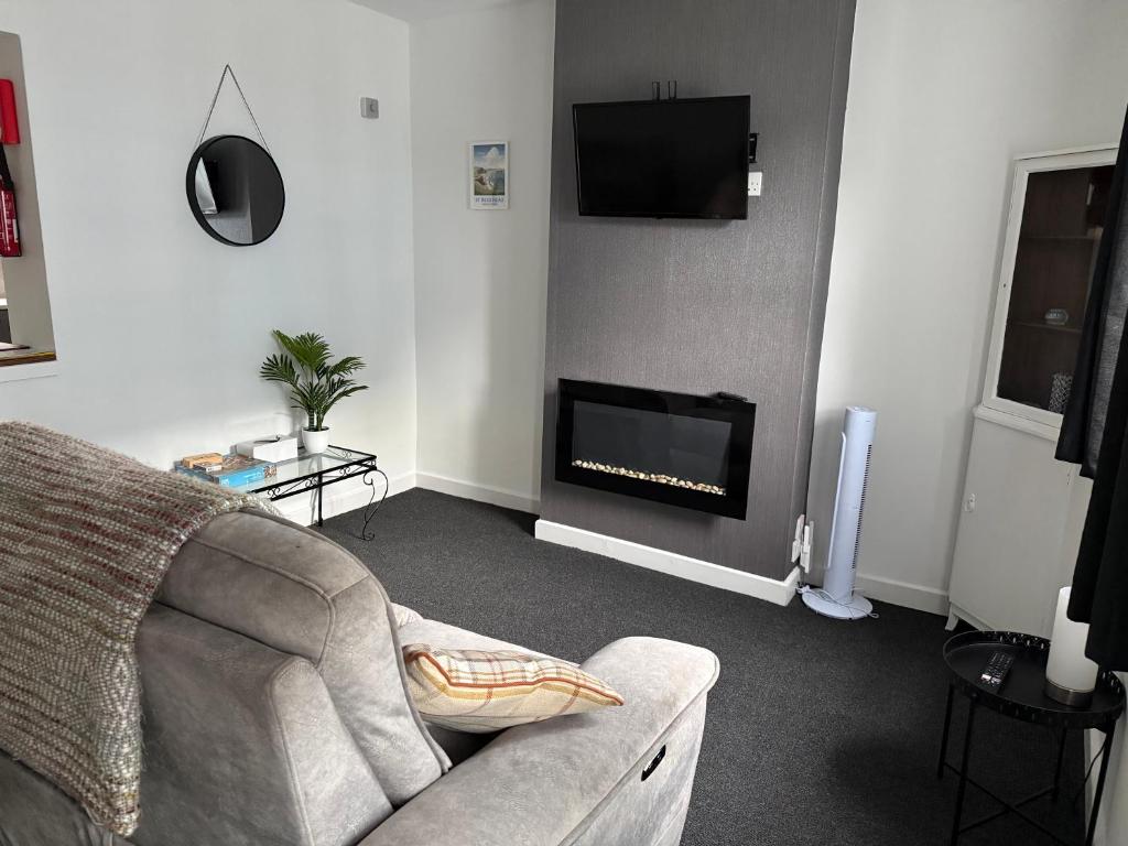 a living room with a couch and a fireplace at 16 Main Street in St Bees