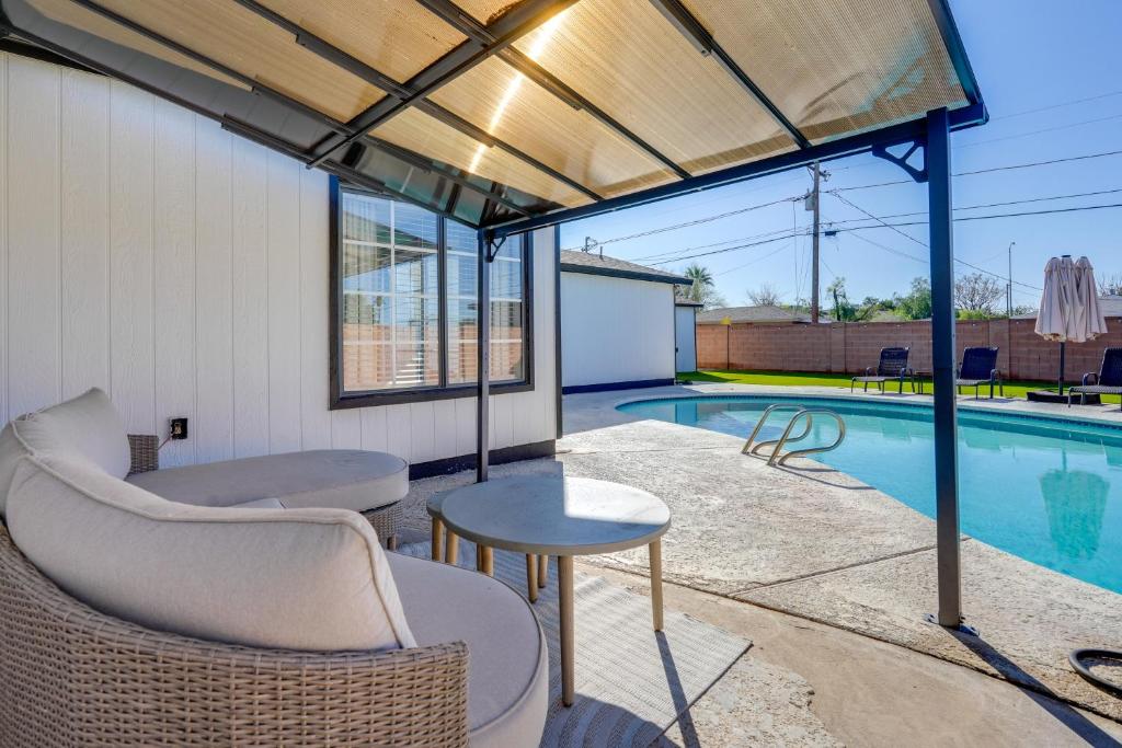 a patio with a table and chairs and a swimming pool at Relax Poolside: Central Group Getaway in Mesa! in Mesa