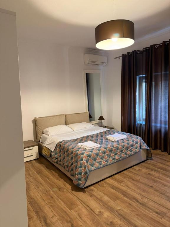 a bedroom with a bed and a large window at Hotel La Cita in Tirana