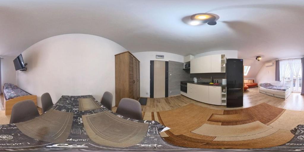 a living room with a table and a kitchen at Apartament Przylesie in Stężyca